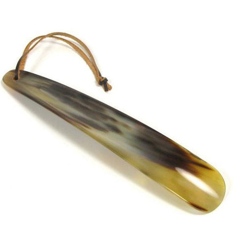 A flat-shaped shoe horn made of natural horn with a brown leather thong strap.