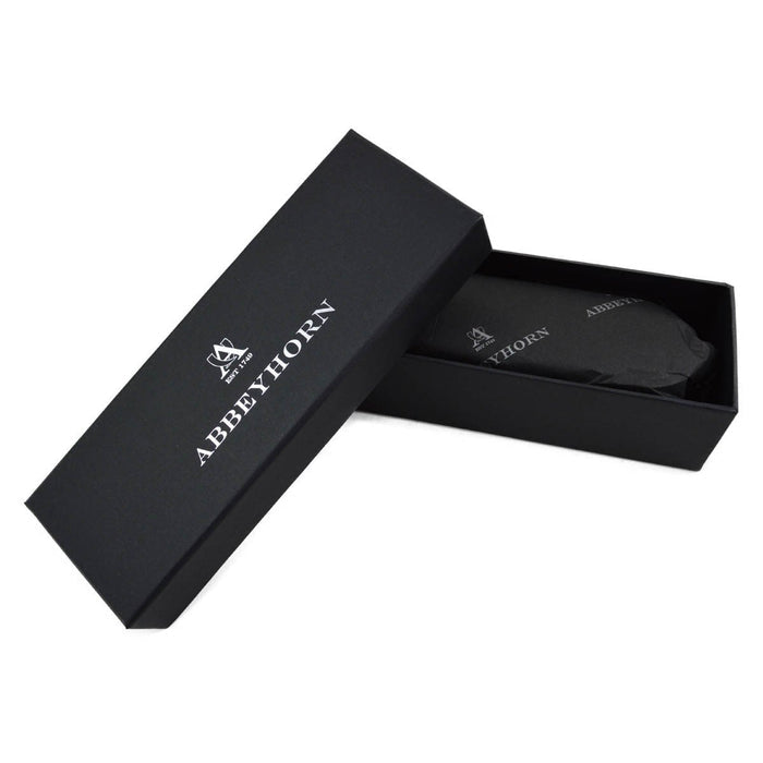 A handcrafted shoe polishing brush with a black and white oxhorn handle and dark bristles, presented on a plain background.