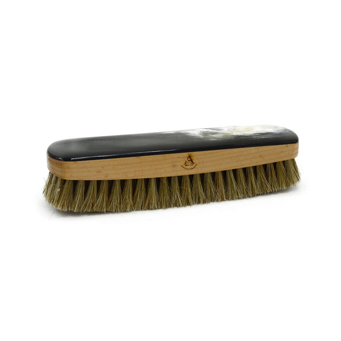 A handcrafted shoe polishing brush with a black and white oxhorn handle and dark bristles, presented on a plain background.