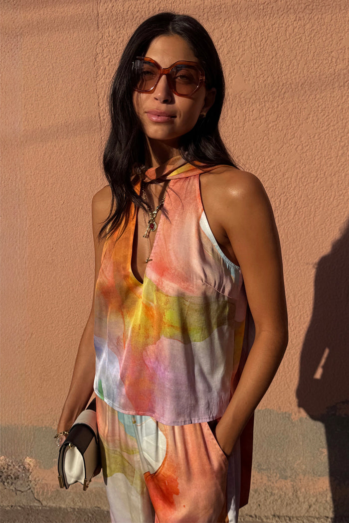 Multi-wear Abstract Lily Top in a multicoloured satin-esque abstract print with a tie neck and matching trousers.