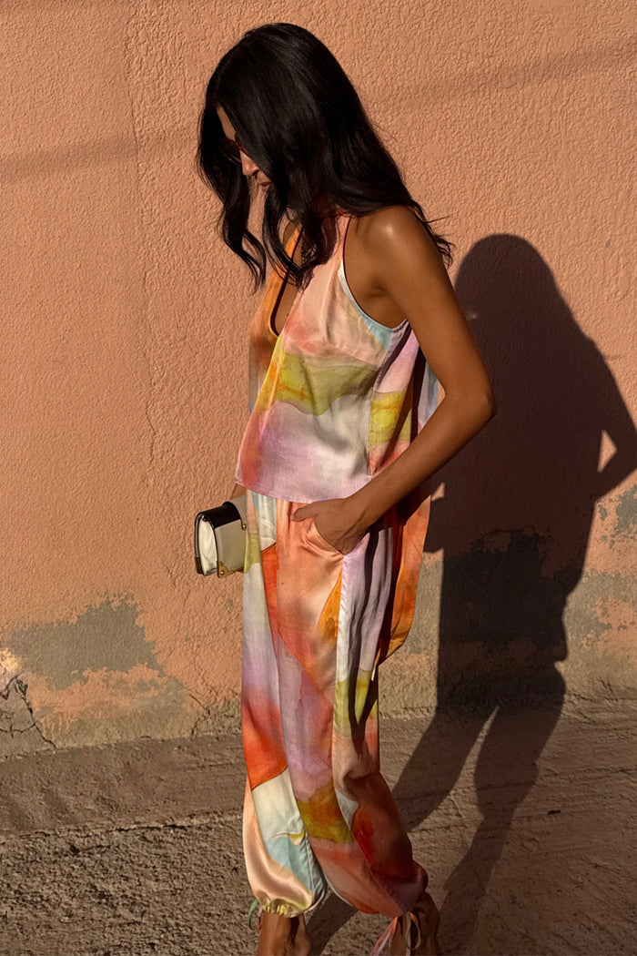 Abstract Lily Top in a multi-coloured print, styled as a multi-wear co-ord set against a pink wall.