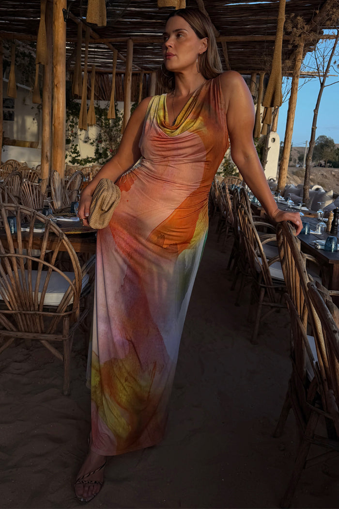 Multicoloured Abstract Malika midaxi dress with a draped neckline, shown on a curve model in a beach restaurant.
