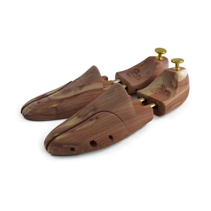 A pair of uncompressed cedar wood shoe trees with brass fitments, displayed in an open position.