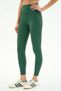 A person in SPLITS59 Airweight High Waist Legging - Arugula and white sneakers with green stripes stands against a light background—ideal for hot yoga.