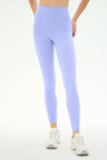 A person wearing SPLITS59 Airweight High Waist Legging in Purple Haze and white athletic shoes stands against a plain white background—ideal for hot yoga or everyday comfort.
