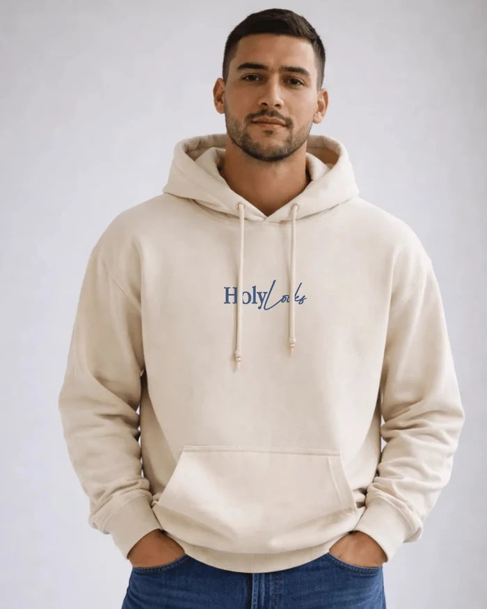 Man wearing a beige hoodie with 'Holy Lake' text on a plain background