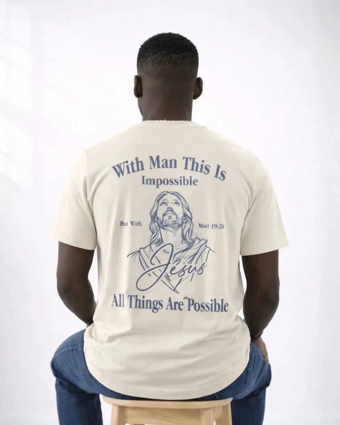 Man wearing a t-shirt with a Jesus illustration and text on the back, sitting on a stool against a white background.