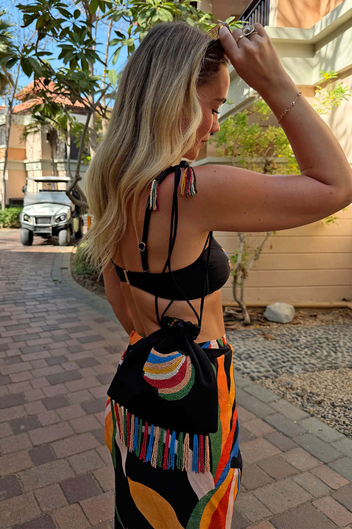 Black Banana Pouch Bag featuring a beaded banana motif and multicolour fringe, styled with a vibrant printed sarong.