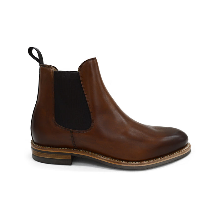 A brown Berwick 1707 Chelsea Boot with a pull tab on the side, showcasing a traditional round-toe shape and a natural welt with a Dainite rubber sole.