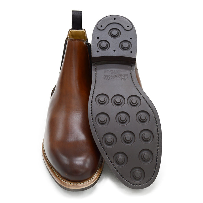 A brown Berwick 1707 Chelsea Boot with a pull tab on the side, showcasing a traditional round-toe shape and a natural welt with a Dainite rubber sole.