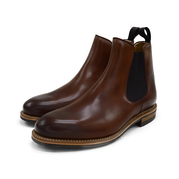 A brown Berwick 1707 Chelsea Boot with a pull tab on the side, showcasing a traditional round-toe shape and a natural welt with a Dainite rubber sole.