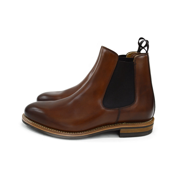 A brown Berwick 1707 Chelsea Boot with a pull tab on the side, showcasing a traditional round-toe shape and a natural welt with a Dainite rubber sole.