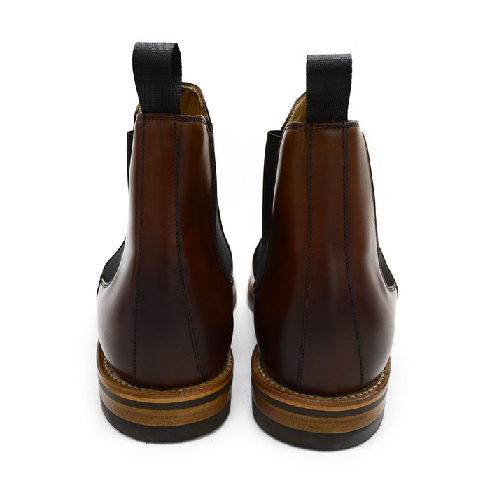 A brown Berwick 1707 Chelsea Boot with a pull tab on the side, showcasing a traditional round-toe shape and a natural welt with a Dainite rubber sole.