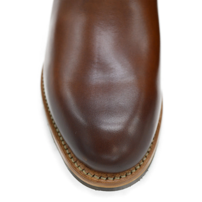 A brown Berwick 1707 Chelsea Boot with a pull tab on the side, showcasing a traditional round-toe shape and a natural welt with a Dainite rubber sole.