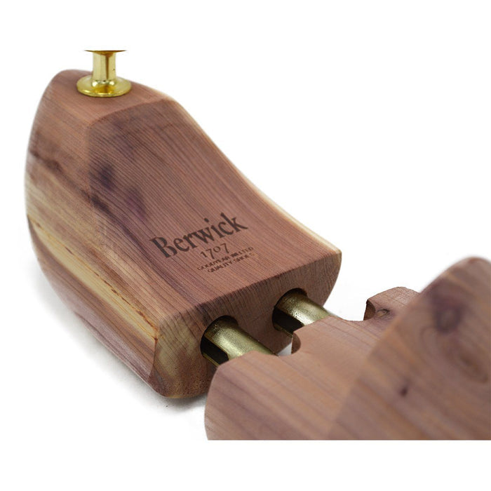 A Berwick 1707 cedar wood shoe tree with brass fitments, displayed in an open position showing the interior structure.