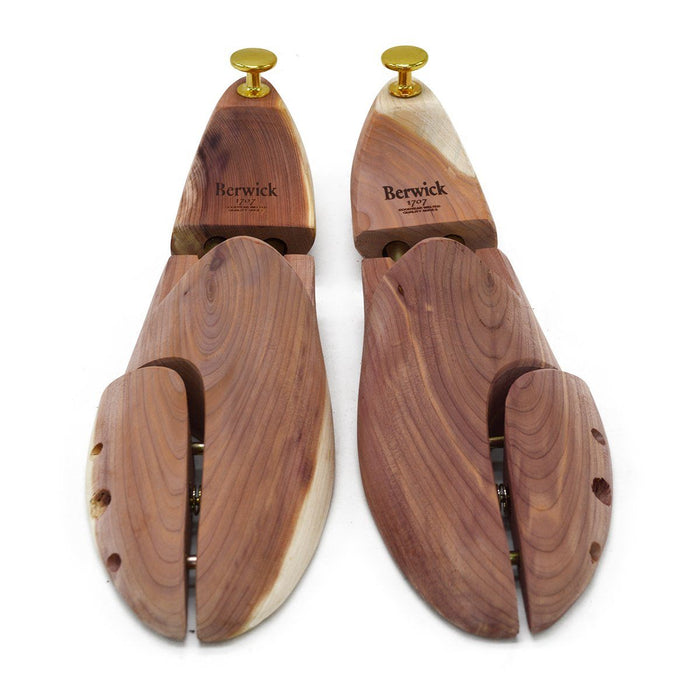 A Berwick 1707 cedar wood shoe tree with brass fitments, displayed in an open position showing the interior structure.