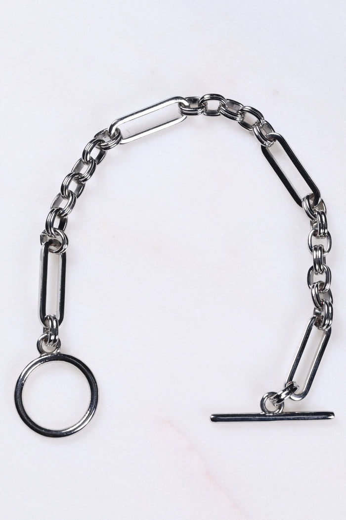 Silver Bespoke Chain Bracelet with a T-bar closure and elegant links on a white marble surface.