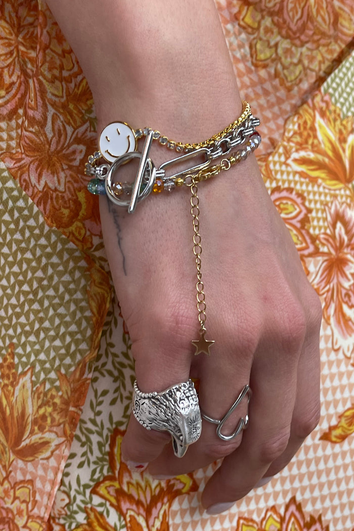 Bespoke Chain Bracelet with a silver T-bar closure, styled with stacked jewellery on a model's wrist.