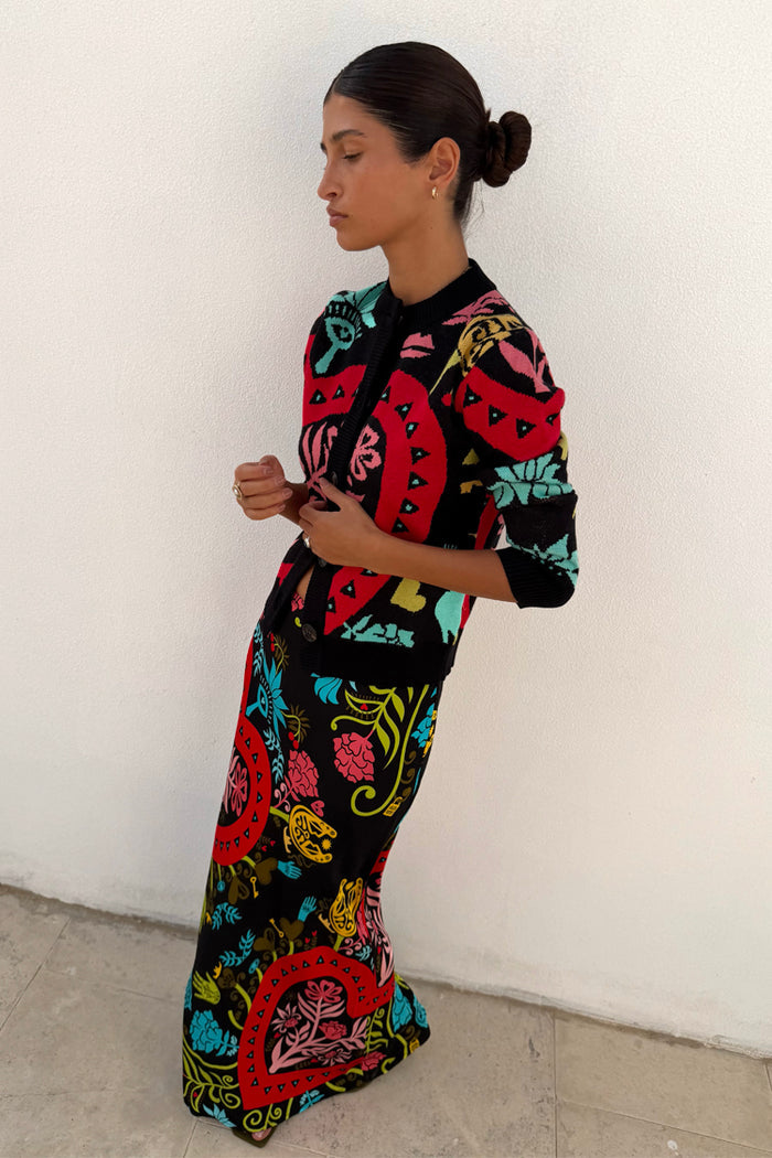 Slim fit Black Amara Hollie Cardigan with iconic hand-painted eye and heart motifs, styled with a matching maxi skirt.