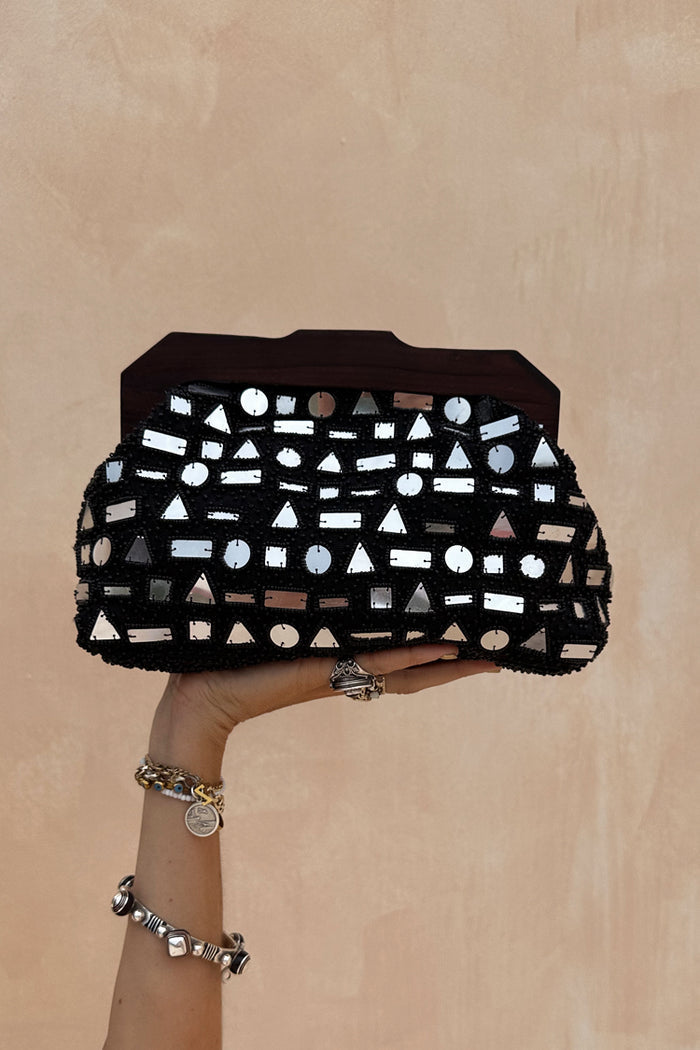Black Beaded Mirror Bag featuring geometric silver mirrors and a dark wooden handle, held up by a hand.
