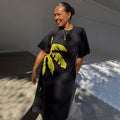 Black Palm Riviera Dress with a yellow palm leaf print and adjustable side cut-out detail.
