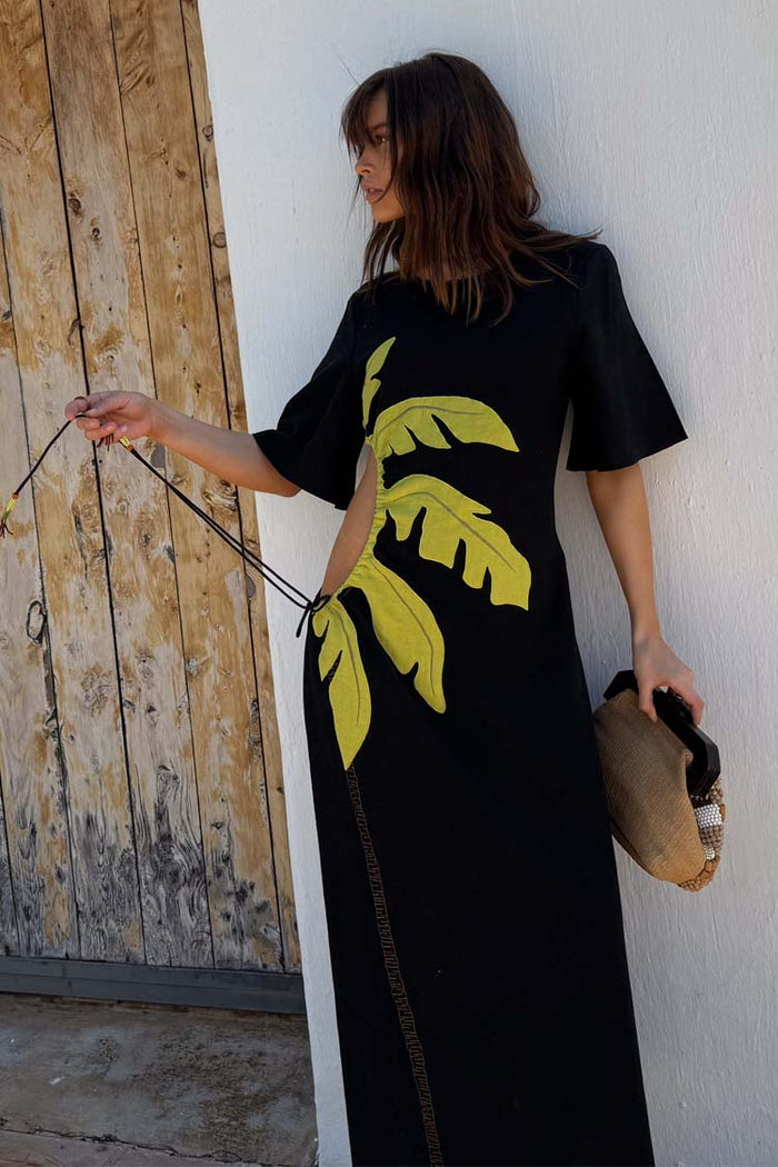 Black Palm Riviera Dress featuring a yellow palm leaf motif and side cut-out with tie detailing.