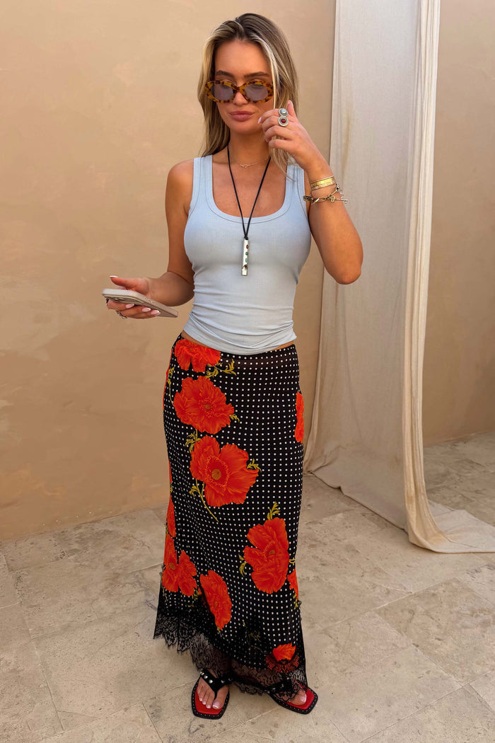 Black Poppy Midi Maeva Skirt with a red floral print and lace trim, paired with a light blue ribbed tank top.
