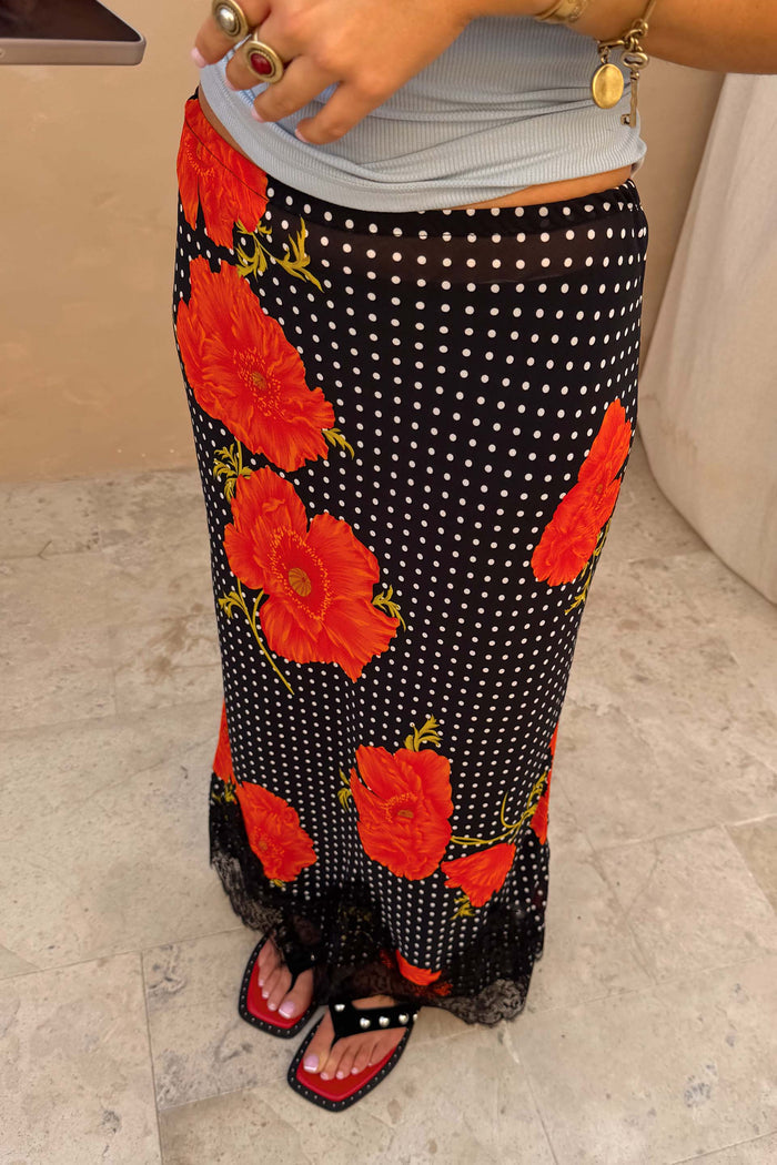 Black Poppy Midi Maeva Skirt with large red poppies, white polka dots, and a delicate black lace hem.