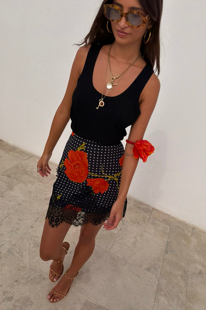 Black Poppy Mini Maeva Skirt featuring a polka dot and poppy print with a black lace trim at the hem.