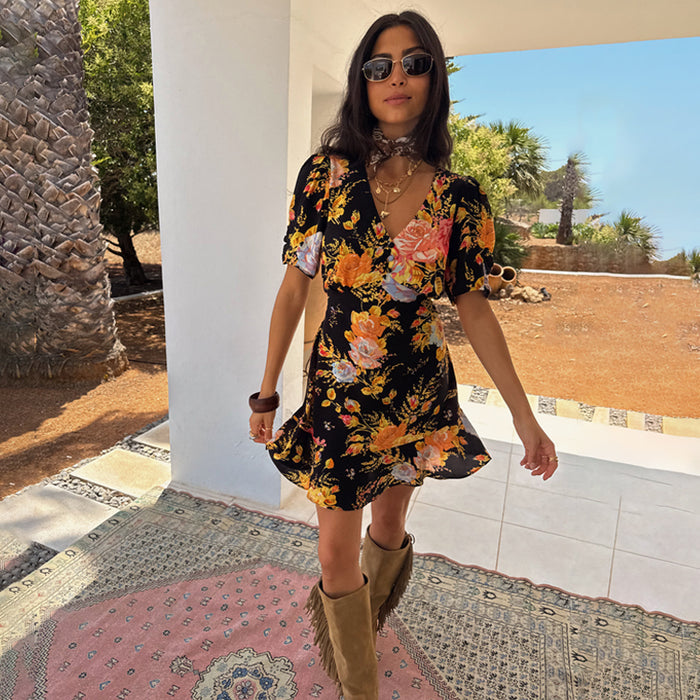 Black Sofia Mini Tea Dress with a floral print and frill hem, styled with tan fringe boots.