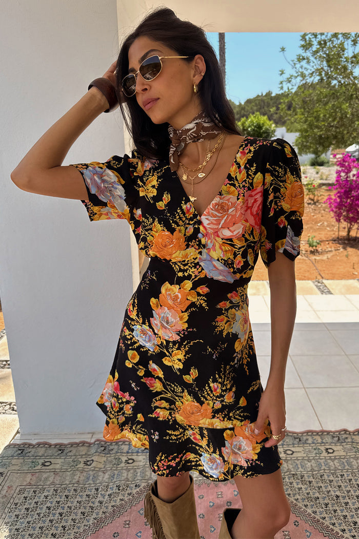 Black Sofia Mini Tea Dress with orange floral print and frilled hem, designed in London for a vacation.