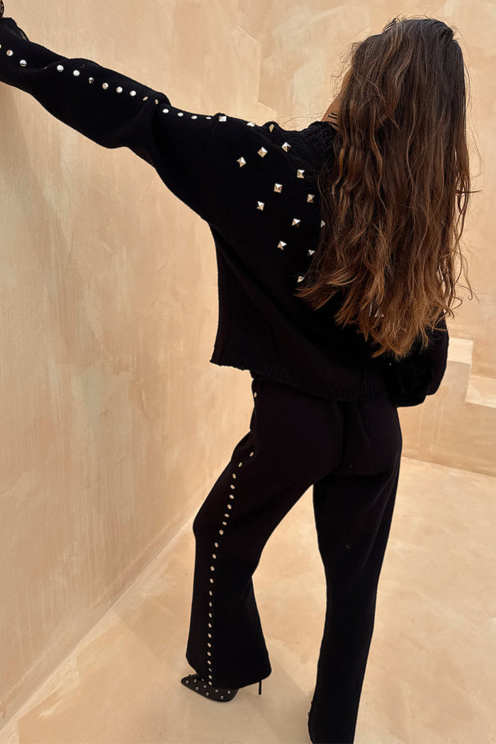 Black Studded Knit Trousers with silver metal studs down the leg, styled with a matching knitted cardigan.