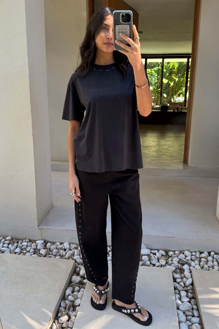 Black Studded T-Shirt in relaxed cotton with silver neckline studs, styled with matching trousers in a mirror selfie.