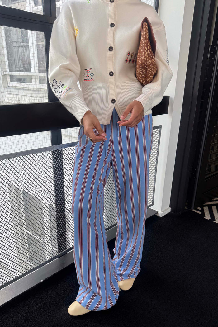 Blue Cotton Stripe Jogger with a red pinstripe print and elasticated waist, styled with an ivory embroidered cardigan.