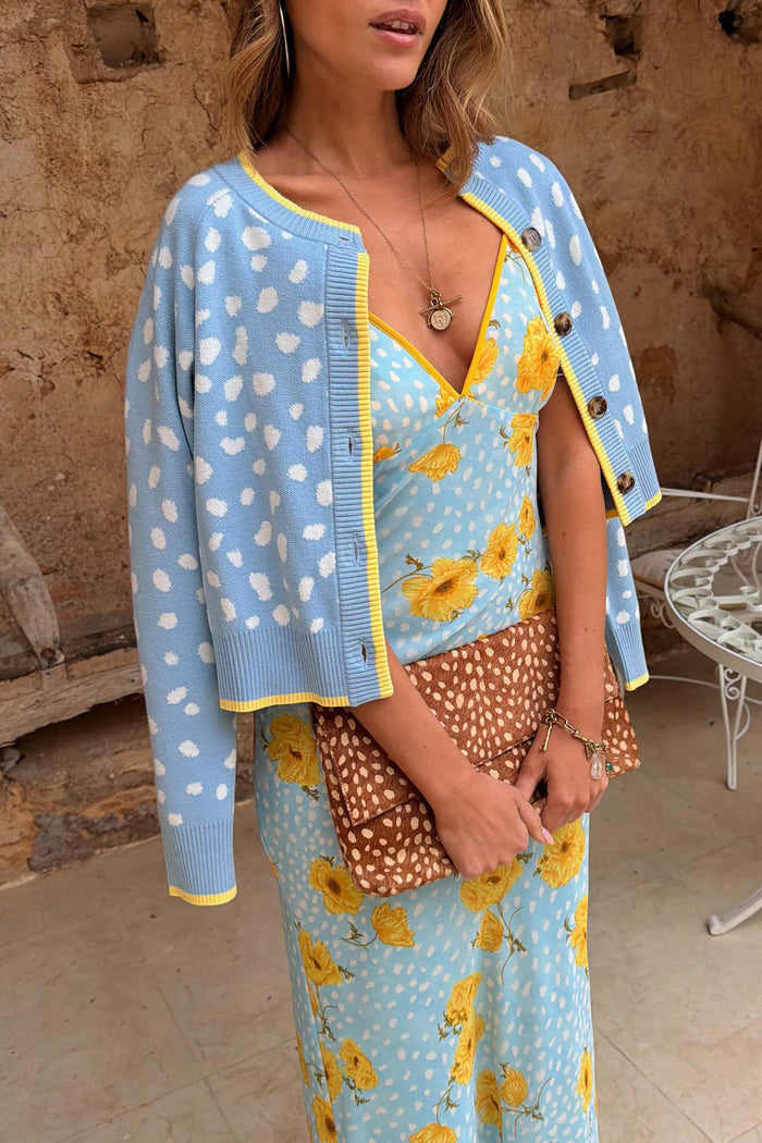 Blue Fawn Cheryl Cardigan with a spotted deer print and yellow trims, layered over a blue floral dress.