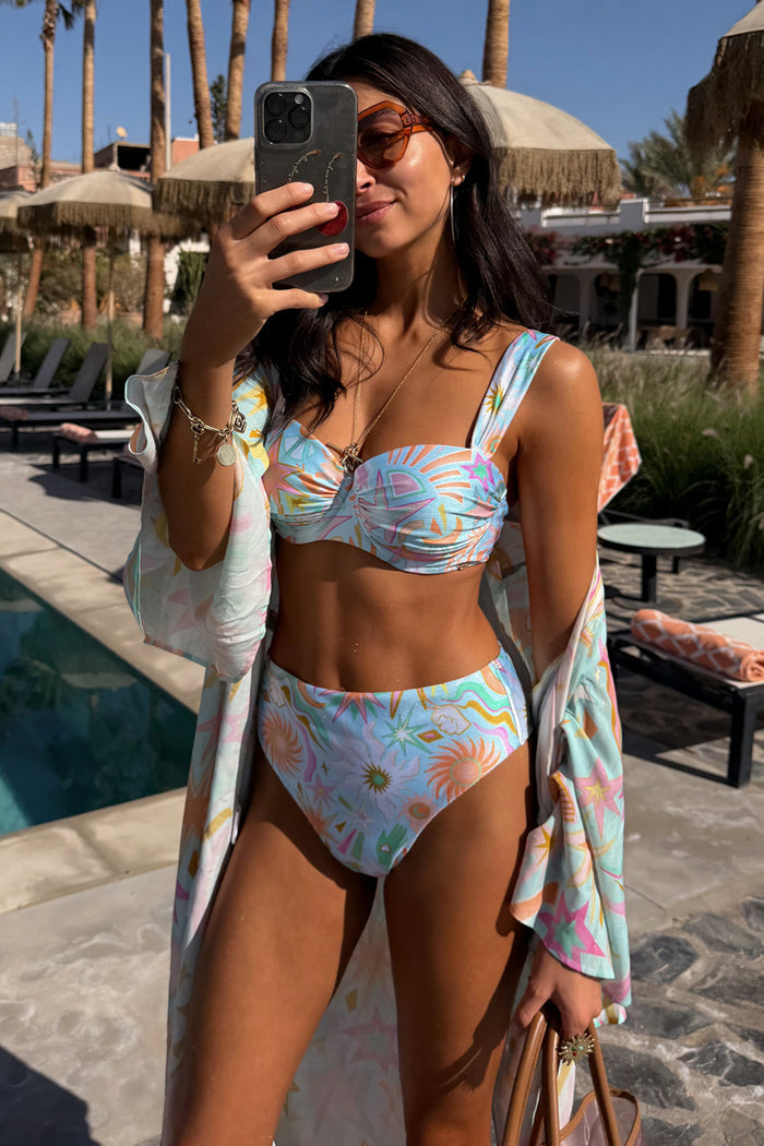 Blue Dreamer High Waist Brief featuring a vibrant sun print, styled poolside with a matching top and cover-up.