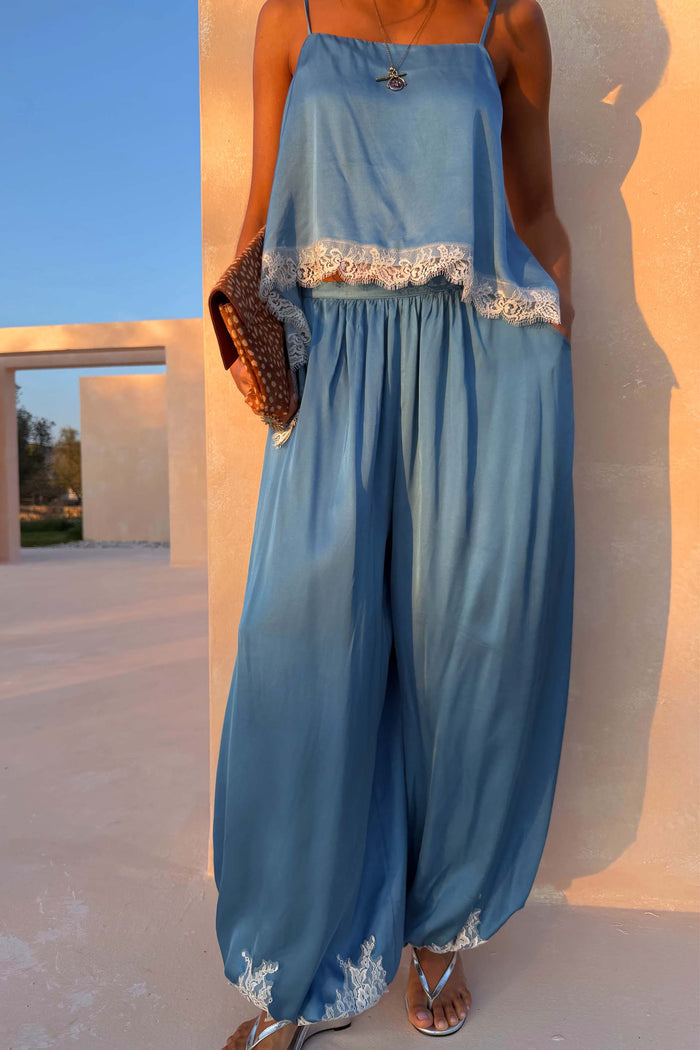 Blue Lace Balloon Trousers in a washed blue satin with delicate white lace trims at the hem and a fluid wide-leg shape.