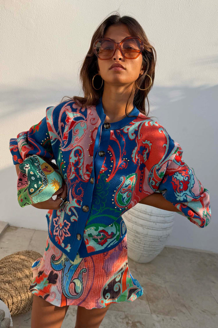 Blue Mari Cardigan with orange and turquoise paisley motifs, gold studs and a button-up front, designed in London.