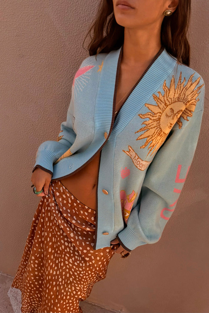 Blue Mystical Cardigan in soft-touch knit with sun and moon jacquard motifs and brown ribbed trims.