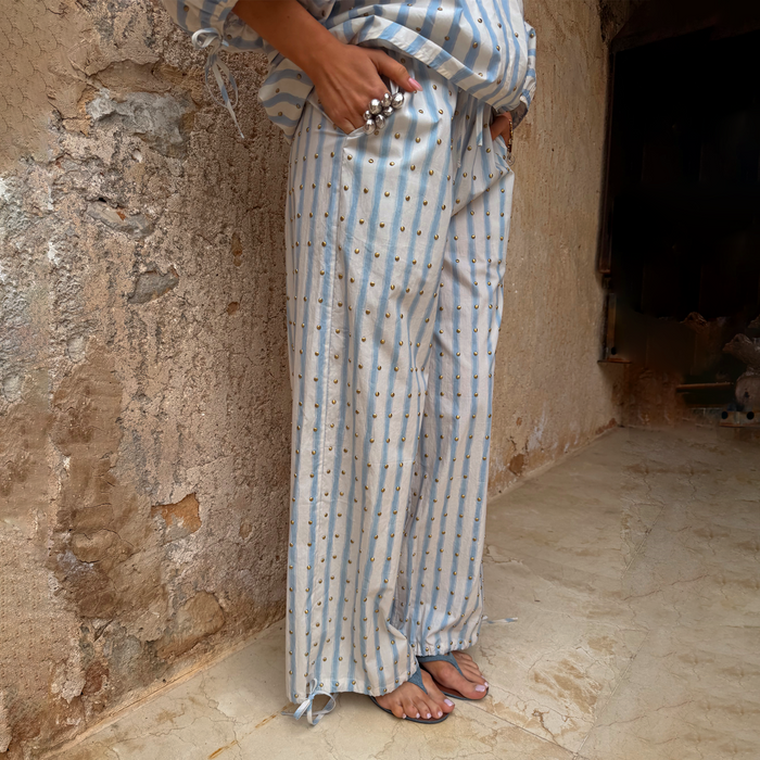 Blue stripe balloon trousers with gold studs and adjustable tie cuffs, styled with a matching co-ord top.