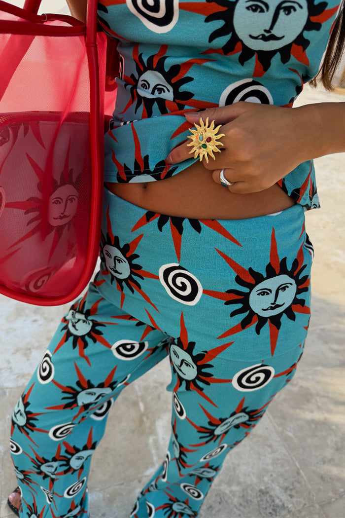 Blue Sun Foldover Trouser featuring Mediterranean sun prints on a blue jersey base with a foldover waistband.