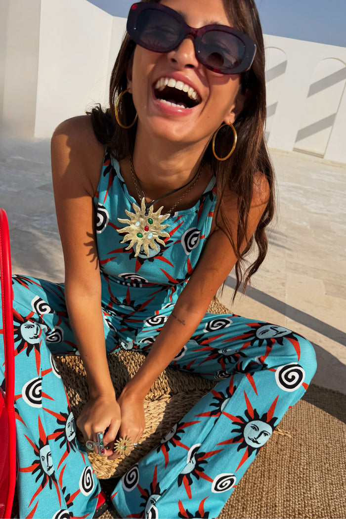 Blue Sun Foldover Trouser and vest with hand-painted sun and swirl motifs in bright blue jersey on a laughing model.