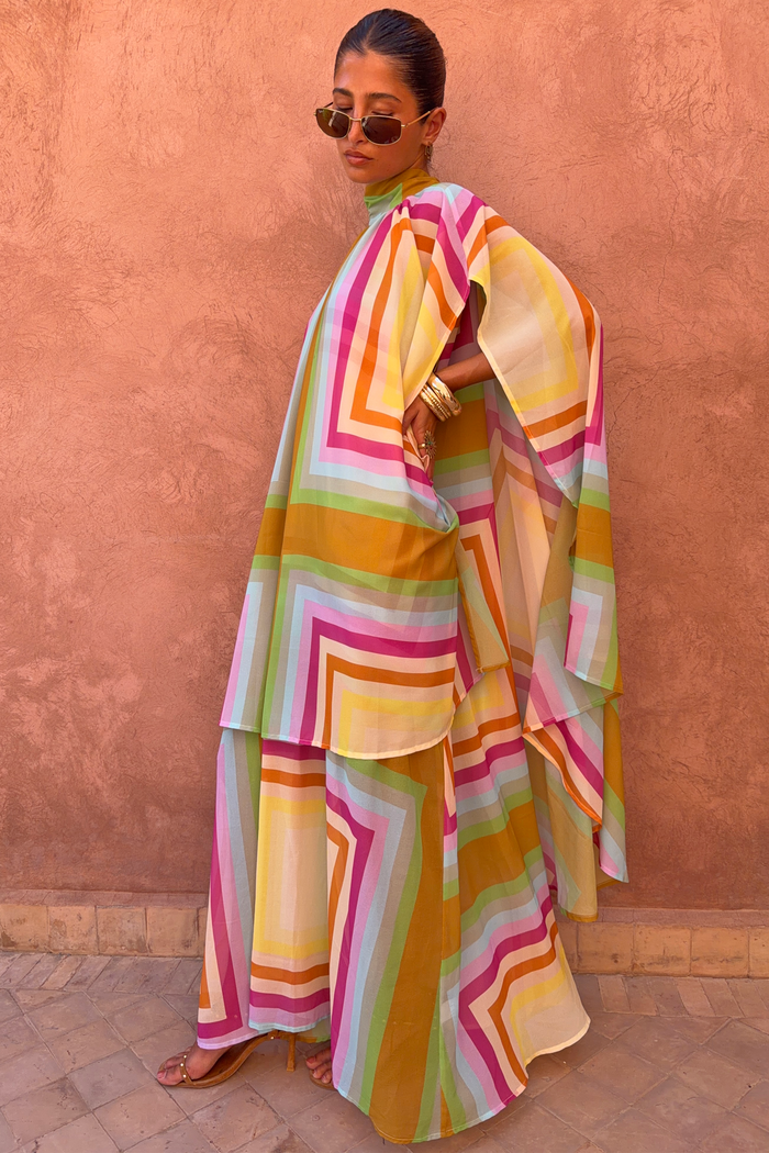 Bright Geo Stevie Maxi Dress with a multi-coloured geometric stripe print and cape sleeves on a model.