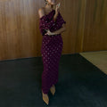 Burgundy Tilly midaxi dress in plissé with gold flecks and lettuce hem, styled off-the-shoulder.