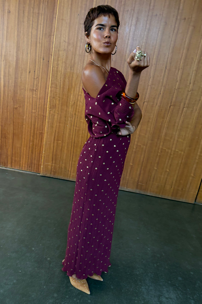 Burgundy Tilly Dress in textured plissé with gold flecks, styled with an off-the-shoulder neckline.