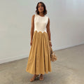 Camel Monika Dress with a white corset-style top, scalloped waist, and a beige pleated cotton midi skirt.