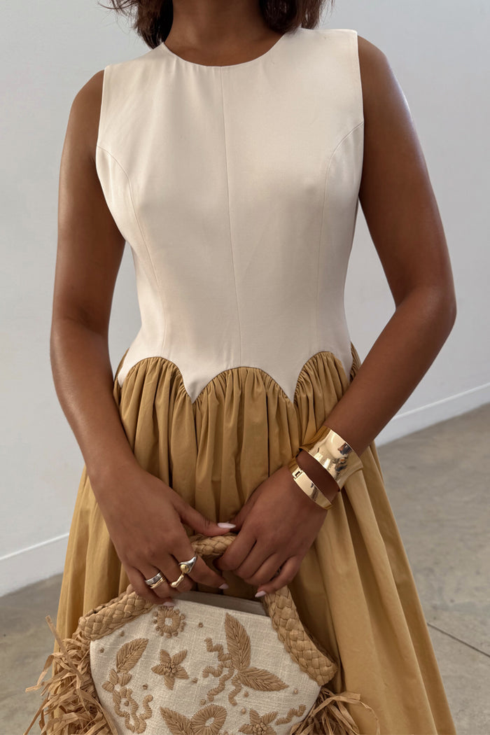 Camel Monika Dress featuring a cream corset-style top with scalloped edging and a camel pleated skirt.