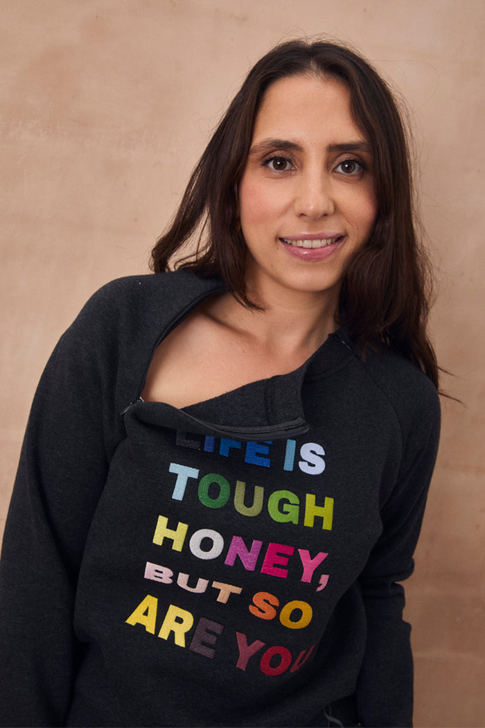 Charcoal sweatshirt featuring colourful "Life is tough honey" embroidery and a functional neckline zip.