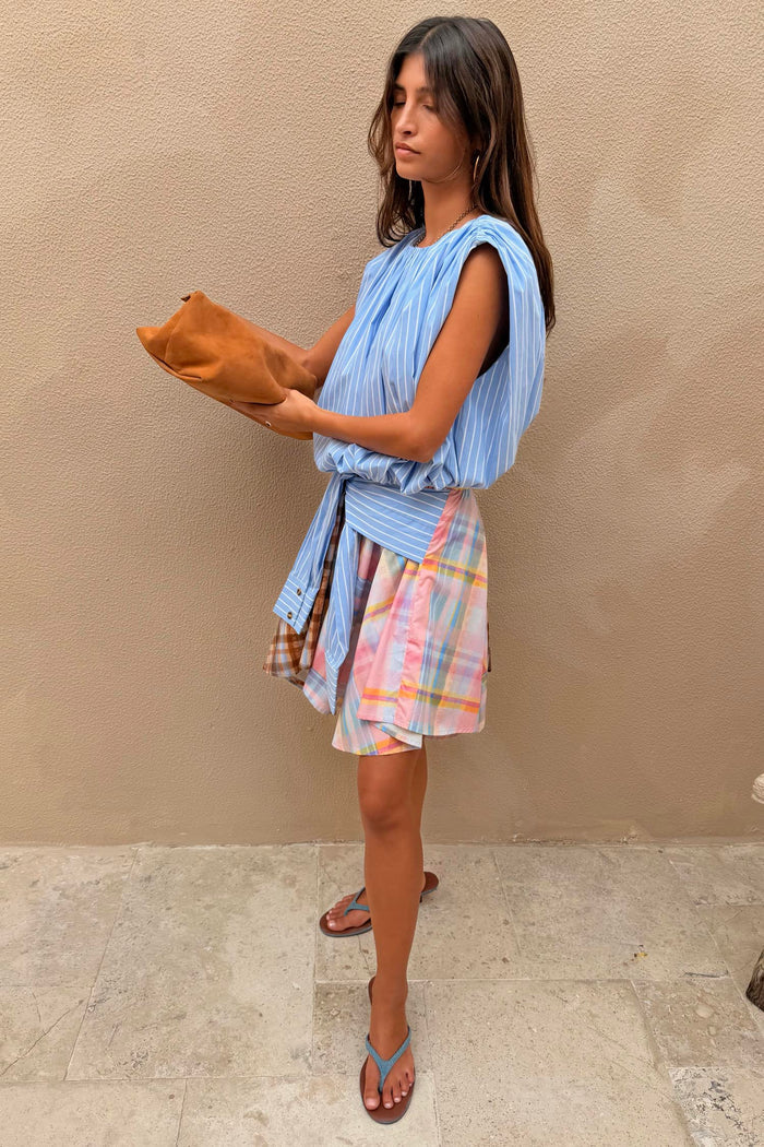 Check Asymmetric Mini Skirt featuring a playful mixed check print, blue stripe tie waist and a draped hanky hem.