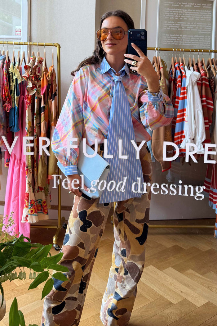 Pastel Check Shirt with a blue stripe pussy bow and camo trousers, shown in a feel good dressing mirror selfie.